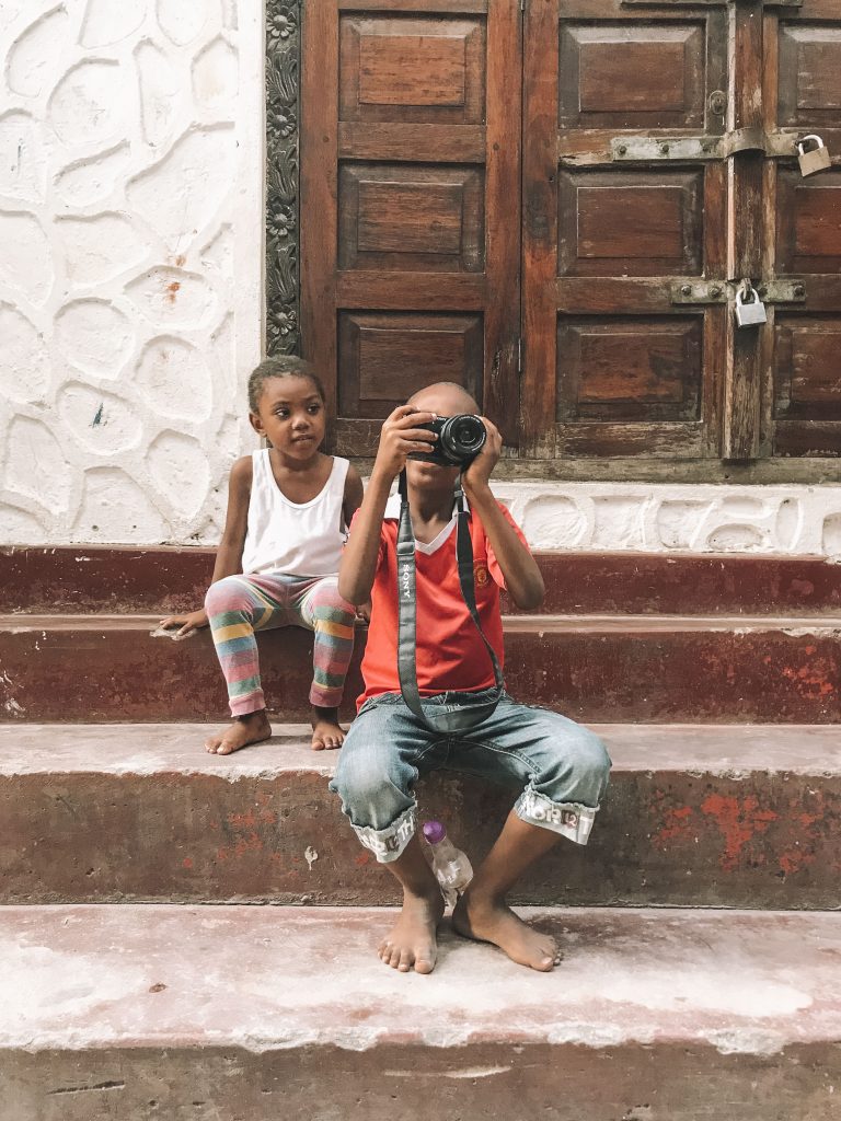 menino com câmera fotográfica na mão em zanzibar