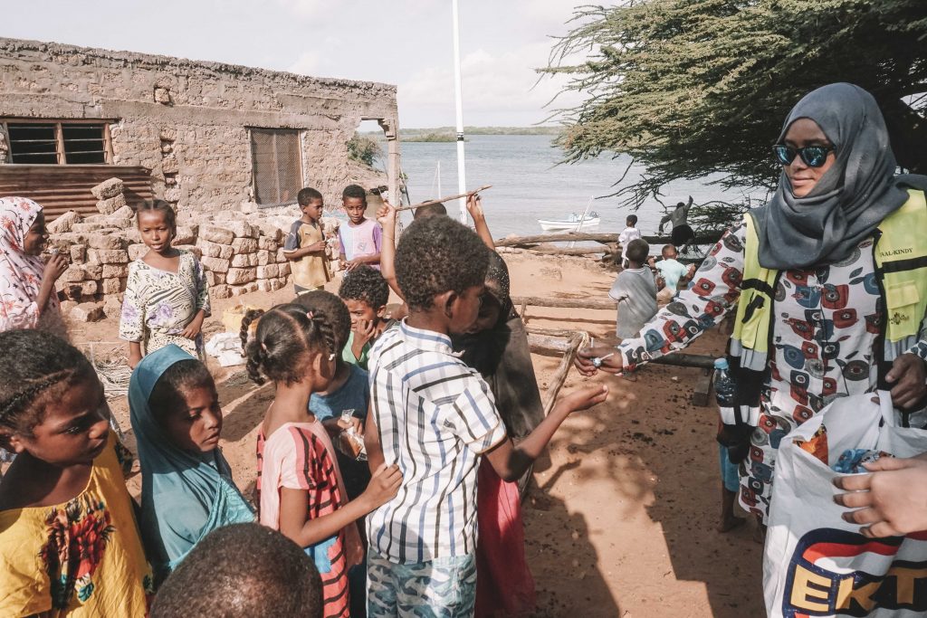 distribuindo doces a crianças em kiwayu