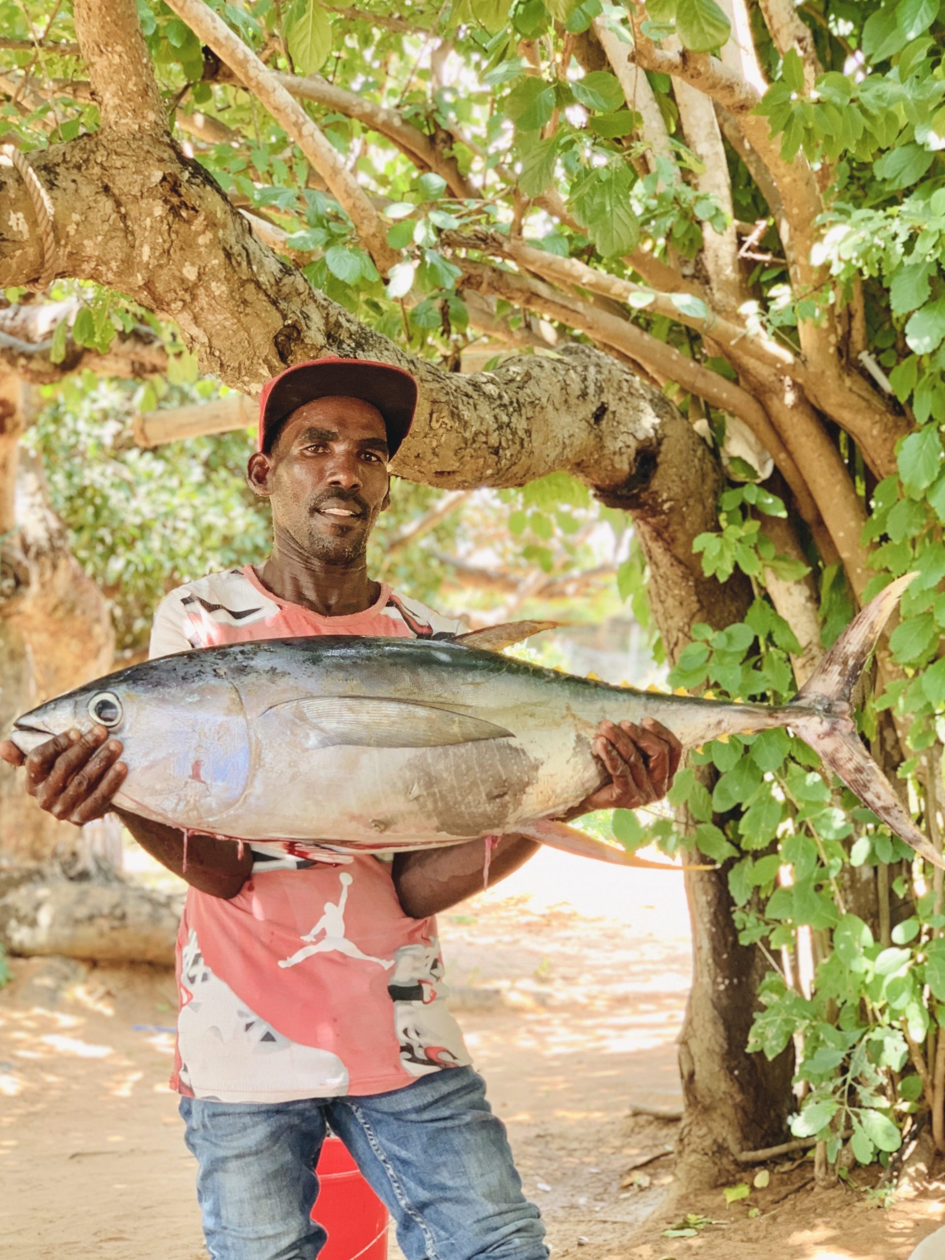 homem carregando atum de 8kg em Lamu no Quênia